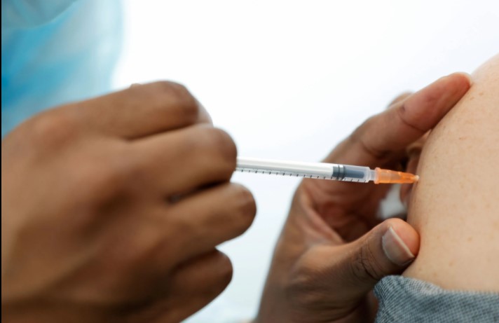 A medical staff administers the Pfizer-BioNTech COVID-19 vaccine to a woman at a coronavirus disease (COVID-19) vaccination center